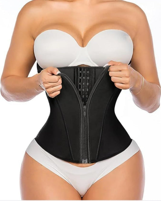 Person wearing a black waist trainer with a white strapless top and underwear set on a plain background